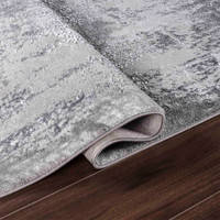 modern abstract acrylic grey rug runner folded on wooden floor
