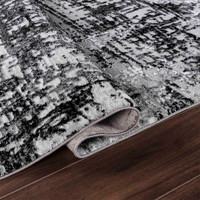 modern abstract lines black rug folded on wooden floor
