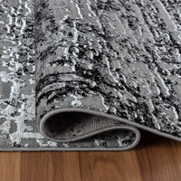 modern abstract lines black rug folded on wooden floor