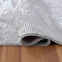 modern abstract water flow grey rug folded on wooden floor