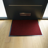 red non-slip dirt trapper mat in front of a door indoors
