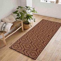 quatrefoil brown doormat runner in a hallway on a wood floor