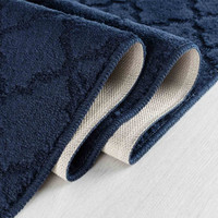 trellis navy doormat folded on wooden floor