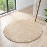 plain beige rug circle in a living space with a window