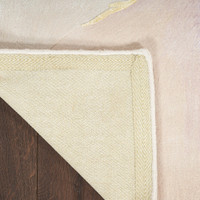 ivory floral rug closeup corner folded on dark wood floor