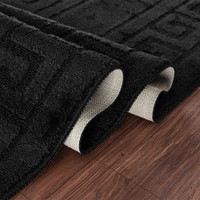 greek key black doormat folded on wooden floor