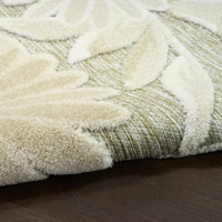 floral ivory sage rug closeup rolled on dark wood floor