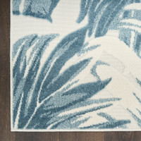 floral ivory blue rug closeup corner on dark wood floor