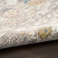 grey traditional rug closeup rolled on dark wood floor