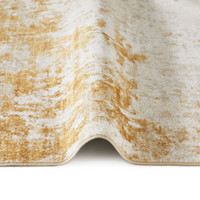 light gold abstract rug closeup fold on a white floor