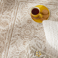 grey khaki traditional rug closeup edge with a plate of food