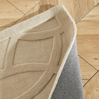 taupe wool rug closeup fold on wood floor