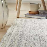 grey striped rug closeup with drink and book