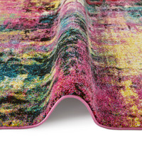 multicolour abstract rug partially folded on a white floor
