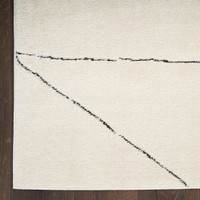 ivory black abstract linear rug closeup corner on dark wood floor