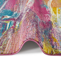 multicolour abstract rug partially folded on a white floor