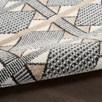 beige black geometric rug partially rolled