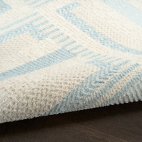 ivory blue geometric rug partially rolled