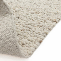 ivory wool rug closeup fold on white floor