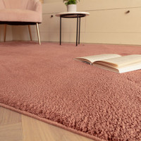 pink plain shaggy rug closeup with a book