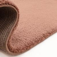 pink plain shaggy rug partial fold on white floor