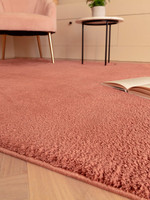 pink plain shaggy rug closeup with a book