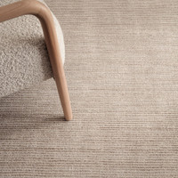 putty plain rug closeup with a chair