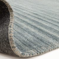 blue plain rug partial fold on white floor