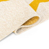 yellow cream eco rug folded on white floor