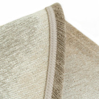 beige peanut shape rug folded on white floor