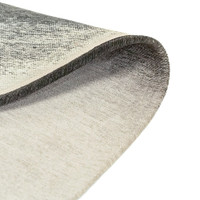 black peanut shape rug folded on white floor