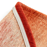 red peanut shape rug folded on white floor