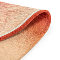 red peanut shape rug folded on white floor