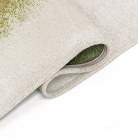 green abstract rug folded on white floor