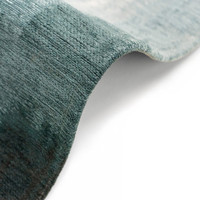 blue abstract rug folded on white floor