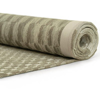 green abstract eco rug rolled on white floor