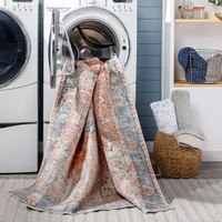 rust traditional rug partially in washing machine in utility room