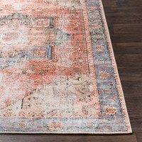 rust traditional rug closeup corner on dark wood floor