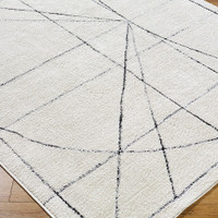 black ivory scandi rug closeup corner on wood floor