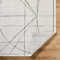 black ivory scandi rug corner fold on wood floor