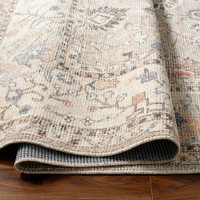 camel traditional rug partially folded on wood floor