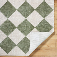 green diamond shaggy rug folded on wood floor