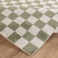 green checker shaggy rug folded on wood floor