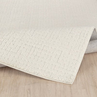 ivory off-white scandi rug folded on wood floor