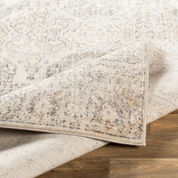 ivory traditional rug folded on wood floor