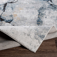 blue abstract rug folded on wood floor