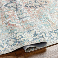 sage traditional rug folded on wood floor