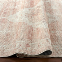 blush traditional rug folded on wood floor