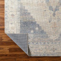 navy traditional rug folded on wood floor
