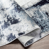navy abstract rug corner fold on wood floor